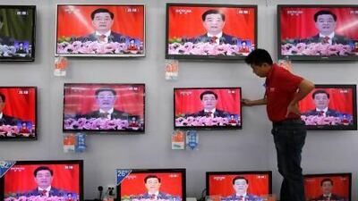 A worker adjusts a television screen showing a live broadcast of Chinese President Hu Jintao speaking at the opening of the 18th Communist Party Congress, at a supermarket in Wuhan, Hubei province, last month. AFP