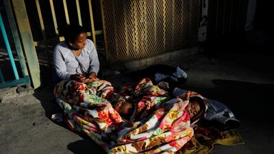A migrant woman, part of a caravan of thousands from Central America trying to reach the United States, sits next to her sleeping babies outside a temporary shelter in Tijuana, Mexico. Reuters