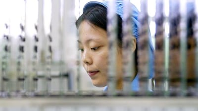 A Huawei worker checks an electronic board for a computer in Dongguan. Kin Cheung / Reuters