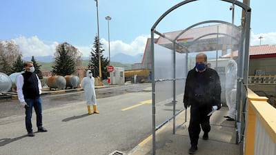 Truck driver Salim Omrah, 52, walks through a disinfection gate at Ibrahim Al-Khalil complex at Zakho outskirt, Dohuk governoate, Iraq. Reuters