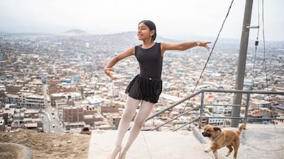The city sprawls out in the background as a young ballerina dances