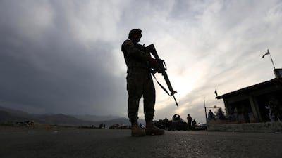 An Afghan National Army (ANA) soldier stand guard at a check point in Jalalabad-Kabul highway, east of Kabul, Afghanistan, Saturday, April 4, 2020. (AP Photo/Rahmat Gul)