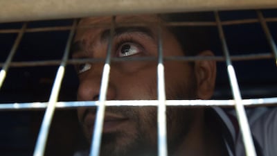 An Indian prisoner, convicted of involvement in the 2006 Mumbai train blasts, looks for his relatives from a police van on his way to a special court in Mumbai on September 30, 2015. Punit Paranjpe / AFP Photo