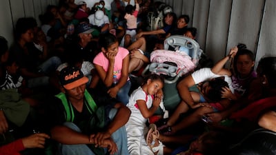 Migrants, part of a caravan traveling to the United States, sit in the back of a truck, as they hitch a ride near Sayula de Aleman, Mexico. Reuters