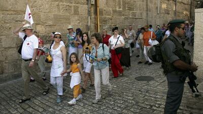 Tourists walk past an Israeli border police officer in Jerusalem's Old City. Ronen Zvulun / Reuters