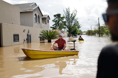 A resident sits in a boat in a flooded street during a rescue mission in Lenasia, south of Soweto. AFP