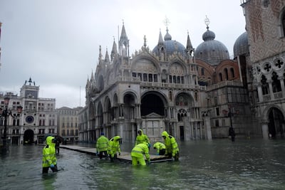 Workers put up a platform at a flooded St. Mark's Square to help pedestrians move around. Reuters