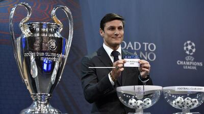 Uefa Champions League final ambassador Javier Zanetti shows the name of Wolfsburg during the draw for the last-16. Faabrice Coffrini / AFP
