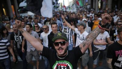 A Juventus supporter holds his hands in the air at the Piazza San Carlo in Turin on Sunday after the club won the Serie A title. Marco Bertorello / AFP / May 4, 2014