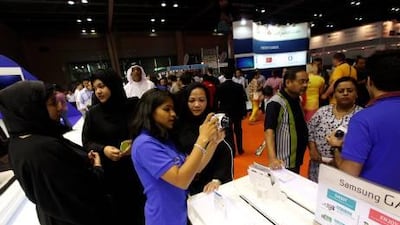 Visitors take a closer look at the latest digital cameras on display at the Gitex Shopper Spring show in Dubai. Visitors negotiated their way around stalls with members of staff thrusting brochures at them and asking them to check out their offers. Satish???