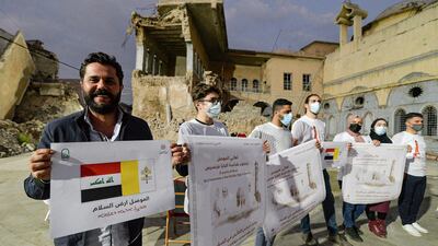 Volunteers stand holding posters welcoming Pope Francis in the ruins of the Syriac Catholic Church of the Immaculate Conception (al-Tahira) in the old city of Iraq's northern city of Mosul ahead of the pontiff's visit later in the week. AFP