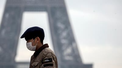 A tourist wears a face mask near the Eiffel Tower in Paris, France. The Global Manufacturing and Industrialisation Summit (GMIS) that was to be held at the Hannover in April will be held virtually due to spread of the coronavirus. EPA