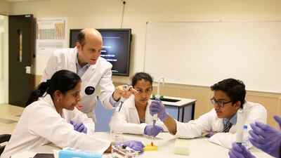 Ezequiel Alvarez-Saavedra, one of the miniPCR co-founders, offers pointers to Gems Modern Academy teacher Srividya, left, and pupils Anoushka Ghosh, centre, and Karun Isaac.
