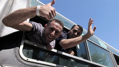 Palestinian prisoners wave as they enter Gaza via the Rafah crossing from Egypt. Israel is freeing more than 1,000 Palestinians in exchange for the Israeli soldier Gilad Shalit, who was captured in June 2006.