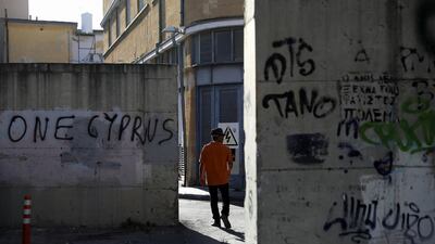 A man walks by an old military post near the UN-controlled buffer zone in Nicosia. After nearly 50 years of division, both sides of Cyprus appear more entrenched than ever. Reuters