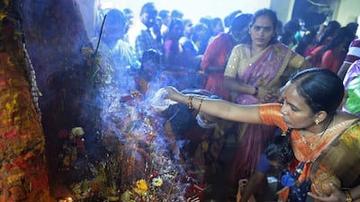 Hindu worshippers offer prayers to statues of snakes, as they mark Naga Panchami festival at a temple in Hyderabad. AFP