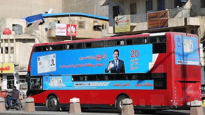 A bus displays a poster advising people to check about their voting information ahead of Iraq's parliamentary elections / AFP