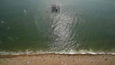 Beachgoers relax by the sea in Brighton, southern England. AFP