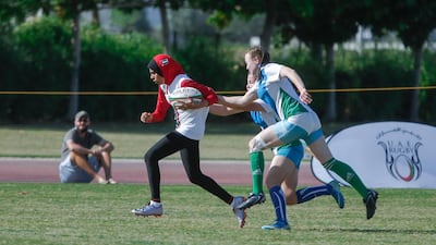 The UAE's Hamda Waleed, centre, makes a run through the Uzbekistan defence during the Under 18 Girls International Tournament at the Dubai Rugby Sevens in December 2016.
