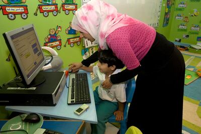 Teacher helps a kindergarten student with a computer game at Al Yasat school in Abu Dhabi. Nicole Hill / The National
