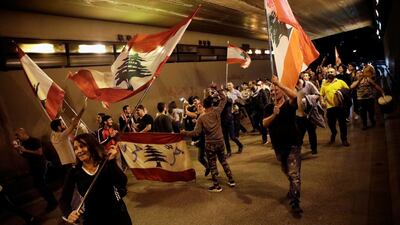Demonstrators carry national flags as they march inside a tunnel in Beirut, Lebanon. REUTERS
