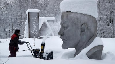 A worker clears snow next to the statue of Vladimir Lenin outside St Petersburg, Russia. AP Photo