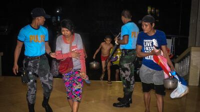 Police assist residents arriving at an evacuation centre, as typhoon Phanfone makes landfall, in Borongan, Eastern Samar province, central Philippines. AFP