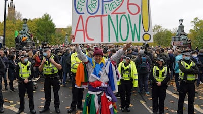 A demonstrator holds a placard calling on the Cop26 summit to 'Act Now'. PA