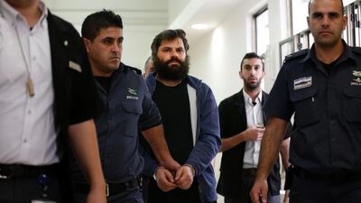 Yosef Haim Ben-David (C), the ringleader of the killing of Palestinian teenager Mohammed Abu Khdeir last year, is escorted by Israeli policemen at the district court in Jerusalem on April 19, 2016. Ahmad Gharabli/AFP