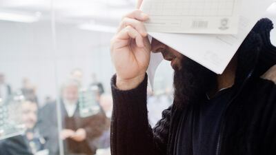 Abu Walaa covers his face as he appears in court accused of being ISIL's chief recruiter in Germany. Julian Stratenschulte/dpa via AP