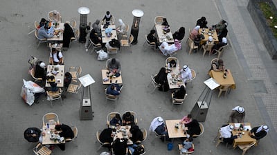 Customers sit at a traditional open-air coffee shop at Kuwait City's Souk Al Mubarakiya. From 24 February, eateries will only be able to offer takeaway services, due to Covid-19 restrictions. EPA