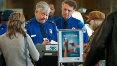 Transportation Security Agency officers review boarding passes at a checkpoint inside Ronald Reagan Washington National Airport.