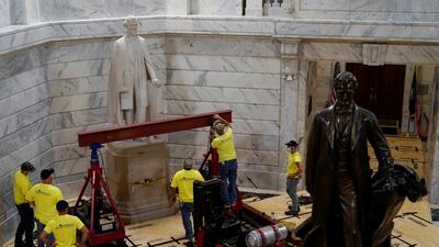 Behind a statue of US President Abraham Lincoln, state workers prepare to remove a statue of Confederate President Jefferson Davis from the rotunda of the Capitol Building in Frankfort, Kentucky, US. Reuters