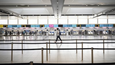 A passenger walks past the deserted check-in desks and passenger facilities in the North Terminal at Gatwick Airport in London. Getty Images