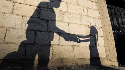 The shadow of a girl receiving a meal for iftar, or the evening meal, to break fast from a member of "Tkiyet Um Ali" humanitarian services centre is cast on a wall in front of her family home in the city of Russeifa in Jordan. Reuters