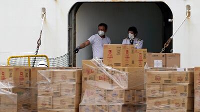 Crew members stand at a vessel entrance next to supplies on the Diamond Princess at the Daikoku Pier Cruise Terminal in Yokohama. EPA