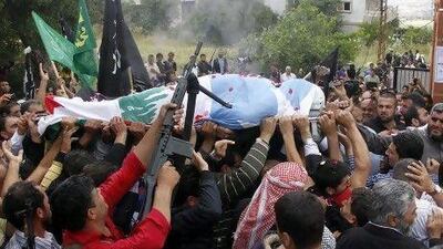 Crowds of mourners and gunmen carry the body of Sheikh Ahmed Abdul Wahid, a Sunni Muslim cleric, during his funeral at his hometown at Al Bireh, north Lebanon, yesterday.