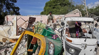 A member of Somalia's security forces walks past destroyed vehicles at the scene of a car bomb blast and gun battle targeting a restaurant in Mogadishu, Somalia on June 15, 2017. Somali survivors described harrowing scenes of the night-long siege of a popular Mogadishu restaurant by Al Shabab Islamic extremists that was ended by security forces. Farah Abdi Warsameh/AP Photo