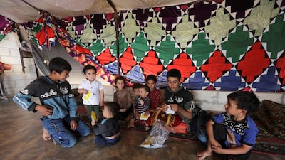 The children of Hussein Mahmoud, an internally displaced farmer, sit together inside a tent in the opposition-held Idlib, Syria. Reuters