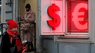A Russian woman leaves an exchange office displaying US dollar and euro currency signs in St Petersburg, Measured over a decade, the US dollar is up 16.8 per cent against the euro, 23.53 per cent against the pound, and 63.2 per cent against the Japanese yen. EPA