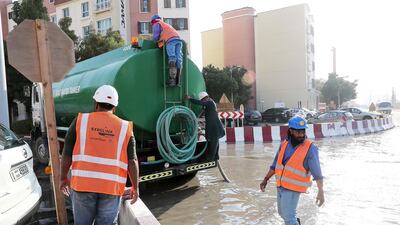Workers at the under construction Dubai Metro site pump out the rain water with the help of water tankers at a street in Discovery Gardens. Pawan Singh / The National