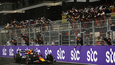 Refd Bull's race winner Sergio Perez passes his team celebrating on the pitwall. Getty