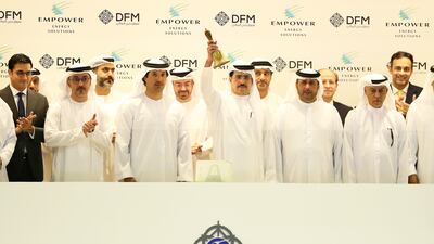Saeed Al Tayer, managing director and chief executive of Dewa (centre) ringing the bell to mark the start of trading of Empower on the Dubai Financial Market. Pawan Singh / The National