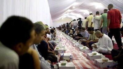 People prepare to share some of the 20,000 meals delivered every day during Ramadan to Muslims and non-Muslims in the iftar tents in the grounds of the Grand Mosque.