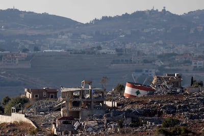 An Israeli flag on a destroyed building and a Lebanese flag painted on a damaged building in the southern Lebanese village of Meiss El-Jabal. AFP