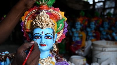 An artisan paints an idol of Krishna in Chennai. AFP