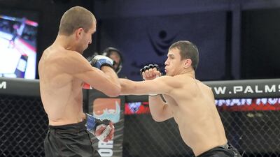 Usman Nurmagomedov (black gloves) fights Roman Golovinov in the lightweight division. Chris Whiteoak / The National