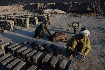 Sitara Wafadar, 18, who dresses as a male in order to support her family, working at a brick factory next to her elderly father (R) in Sultanpur village in Surkh Rod district, in Afghanistan's eastern Nangarhar province. Noorullah Shirzada / AFP