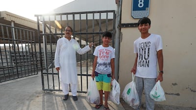 (R-L) Pakistani brothers, Ahmed, 14, and Mohammad Haris,13, hold bags of meat they just had butchered at the Abu Dhabi Municipality Public Slaughter House.