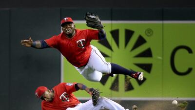 Minnesota Twins right fielder Miguel Sano, top, and second baseman Eduardo Nunez collide in right field while chasing a fly ball hit by Los Angeles Angels’ Yunel Escobar who was thrown out at third base trying to stretch a double during the fourth inning of a baseball game in Minneapolis. David Joles / Star Tribune via AP